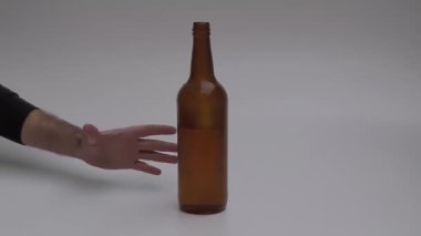 Bira şişesi eliyle bir adam tarafından yok edilir. Belki de alkol alışkanlığını bırakmak istiyordur..