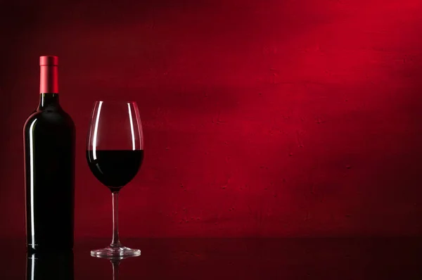 Bir şişe kırmızı şarap ve cam. — Stok fotoğraf