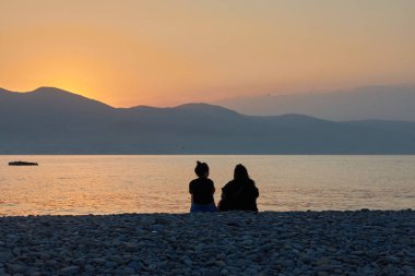 Gün batımında sahilde bir çift.