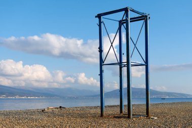 Kumsalda demir yapı, gökyüzü denizi.