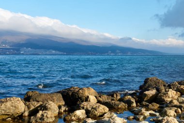 Sea shore and clouds over the mountains