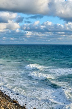 Denizde fırtına, mavi gökyüzünde bulutlar