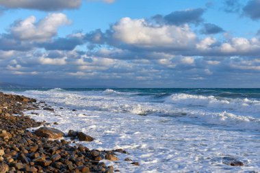 Denizde fırtına, mavi gökyüzünde bulutlar