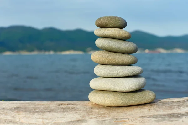 stack of stones on the background of the sea and mountains