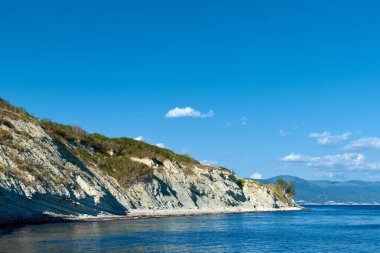 Kayalık bir kıyı ve mavi gökyüzü ile manzara
