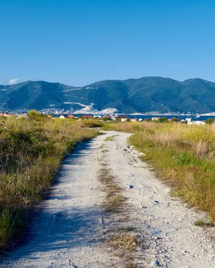 Toprak yol ve dağlarla kaplı manzara