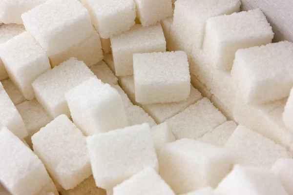 Cubes of sugar on a white background. Many cubes of sugar close-up.