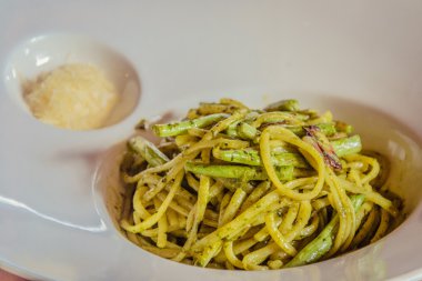 Makarna al pesto ile yeşil fasulye hizmet ve rendelenmiş parmesan