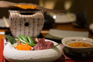 Miso soslu ızgara wagyu bifteği ve küçük bir kömür ocağında yaprak.