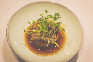 Porselen kasede ördek ciğeri ile pişirilmiş daikon.