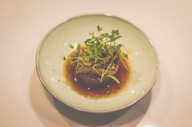 Porselen kasede ördek ciğeri ile pişirilmiş daikon.