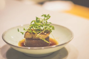 Porselen kasede ördek ciğeri ile pişirilmiş daikon.