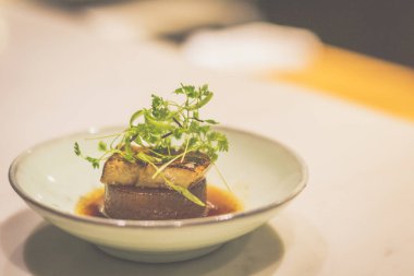 Porselen kasede ördek ciğeri ile pişirilmiş daikon.