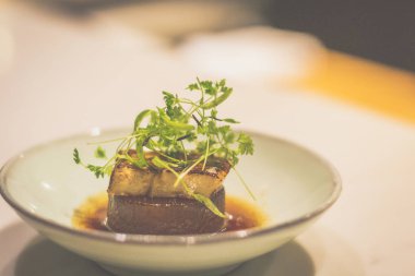 Porselen kasede ördek ciğeri ile pişirilmiş daikon.