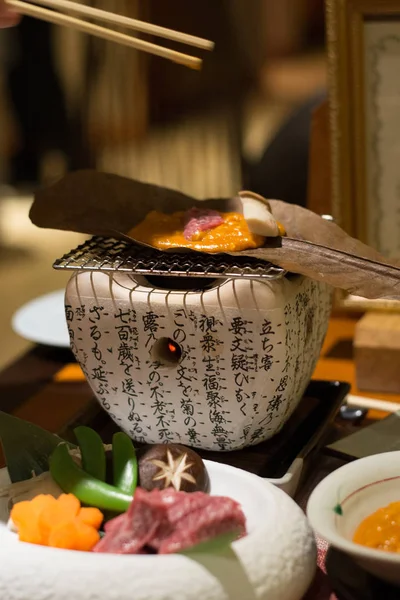 Grilled wagyu beef on miso sauce and a leaf on a small charcoal stove — ストック写真