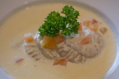 Krema soslu İtalyan mantısı ve beyaz tabakta doğranmış domates.