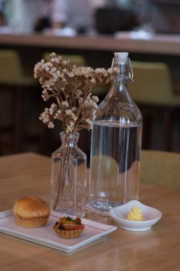 Meyveli tart, ekmek, tereyağı ve bir şişe su.