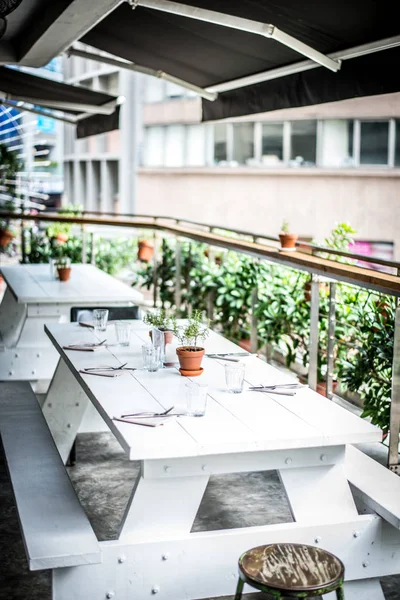 Lantlig lantlig restaurang med vita väggar, bordssittplatser och lampor — Stockfoto