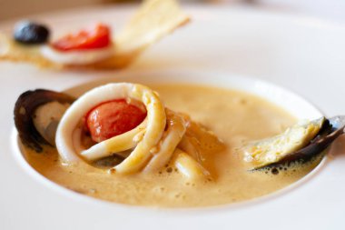 Midye, kalamar, domates, sarımsak ve karidesli kremalı deniz ürünleri çorbası.