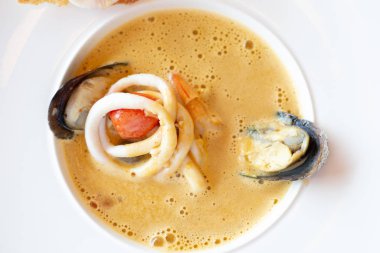 Midye, kalamar, domates, sarımsak ve karidesli kremalı deniz ürünleri çorbası.