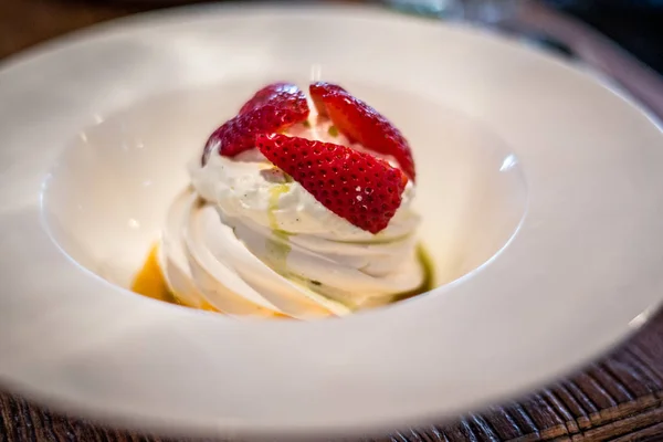 Pavlova med vaniljkräm och färska jordgubbar och passionsfrukt coulis — Stockfoto