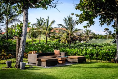 Bahçede yastıklı ve ağaçlı olarak otururlar.