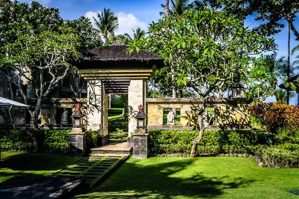 Porta e architettura balinese e fontane con alberi e flora che la circondano — Foto Stock