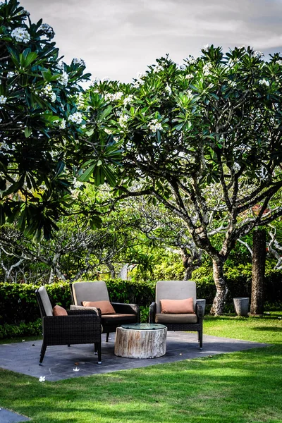 Jardín al aire libre asientos en un jardín con almohadas y muchos árboles —  Fotos de Stock