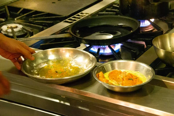 Шеф-повар в форме на кухне готовит бучетту и чиксен пикката — стоковое фото