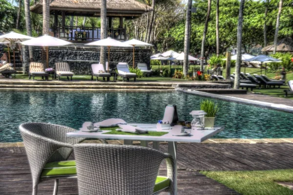 Mesa de jardim com guardanapos e utensílios de mesa ao lado de uma piscina — Fotografia de Stock