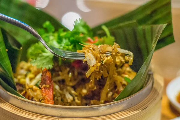 Kway char frito teow macarrão de arroz plano com salsa em cima e servido em folha de banana em uma cesta de bambu — Fotografia de Stock