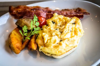 Pastırmalı mantar yumurtası ve beyaz tabakta patates dilimleri.