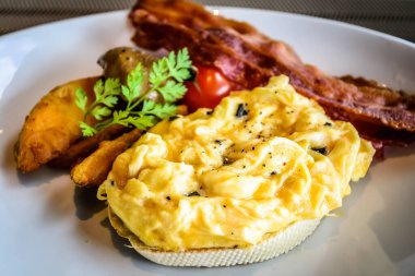 Pastırmalı mantar yumurtası ve beyaz tabakta patates dilimleri.