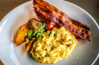 Pastırmalı mantar yumurtası ve beyaz tabakta patates dilimleri.