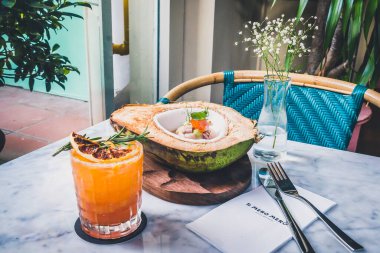 Hamachi ve Hindistancevizi Ceviche Aguachile taze, yeşil hindistan cevizi, amber çiçeği sütü, alabalık yumurtası ve avokado püresi ve kan portakalı Margarita Mezcal, ev yapımı portakallı soda, limon suyu, solucan tuzu