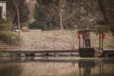 Çin gondolu, iskelede park etmiş kırmızı fenerli ahşap bir tekne.