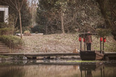 Çin gondolu, iskelede park etmiş kırmızı fenerli ahşap bir tekne.