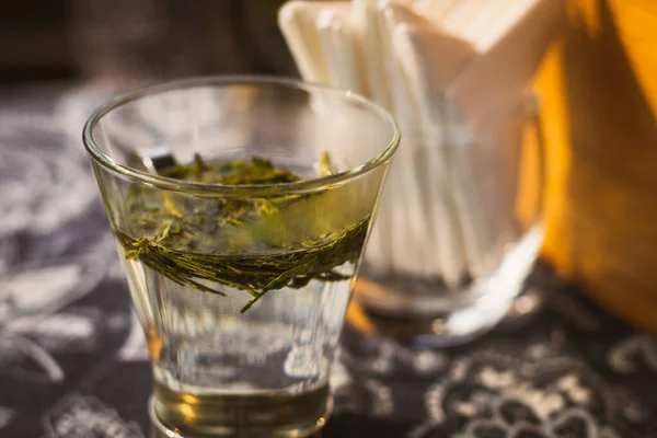 Longjing ejderhası çay yaprakları sıcak suyla küçük bardakta.