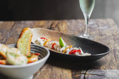 Limon suyu, arpacık soğanı, limon ve kızarmış sarımsaklı Lubina Ceviche.