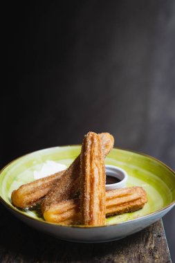 Çikolata soslu ve şekerli bir kase churros.