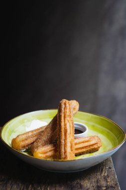 Çikolata soslu ve şekerli bir kase churros.
