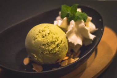 Bir top kibrit yeşil çay, dondurma ve badem gevreği ve krem şanti ve nane yaprağı.