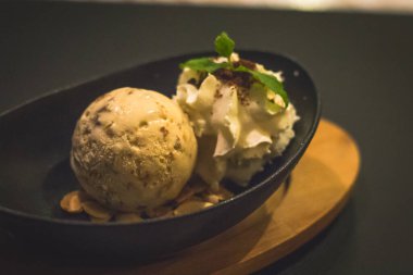 Hindistan cevizli dondurma, badem gevreği, krema ve nane yaprağı topu.