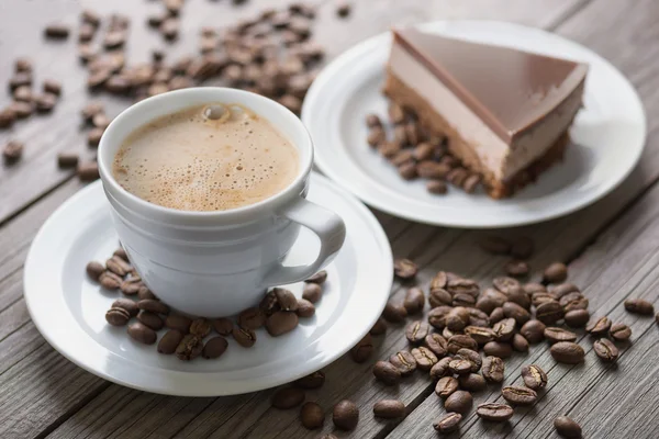 Cangkir dengan kopi di latar belakang kayu . — Stok Foto