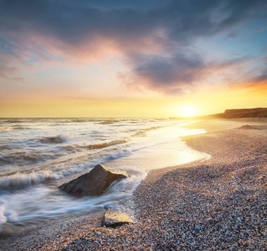 Deniz kıyısında gündoğumu sırasında