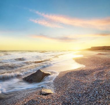 Deniz kıyısında gündoğumu sırasında