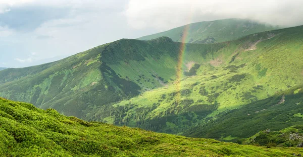 Regenbogen unter Bergrücken — Stockfoto