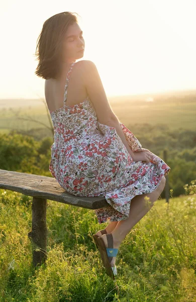 Dziewczyna na ławce podczas zachodu słońca — Zdjęcie stockowe