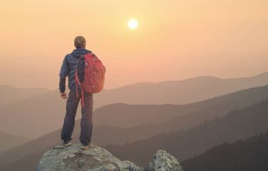 Gün batımı sırasında yüksek kayalar tepe üzerinde turist. Spor ve aktif bir yaşam concep