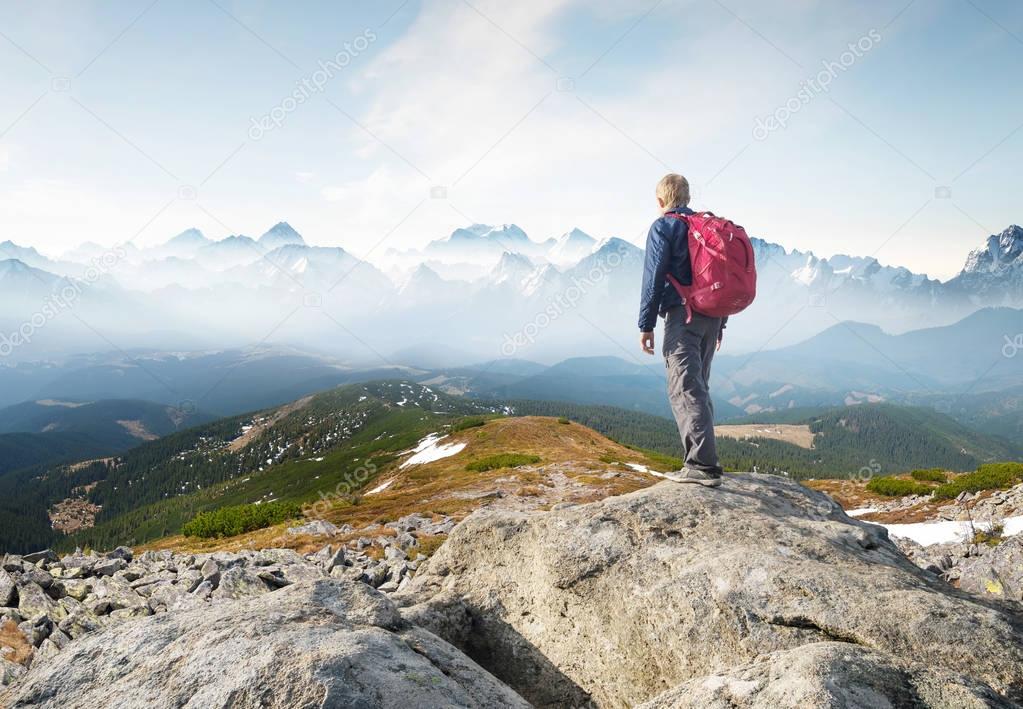 Mountain tourist on the high rock. Sport and active life concept